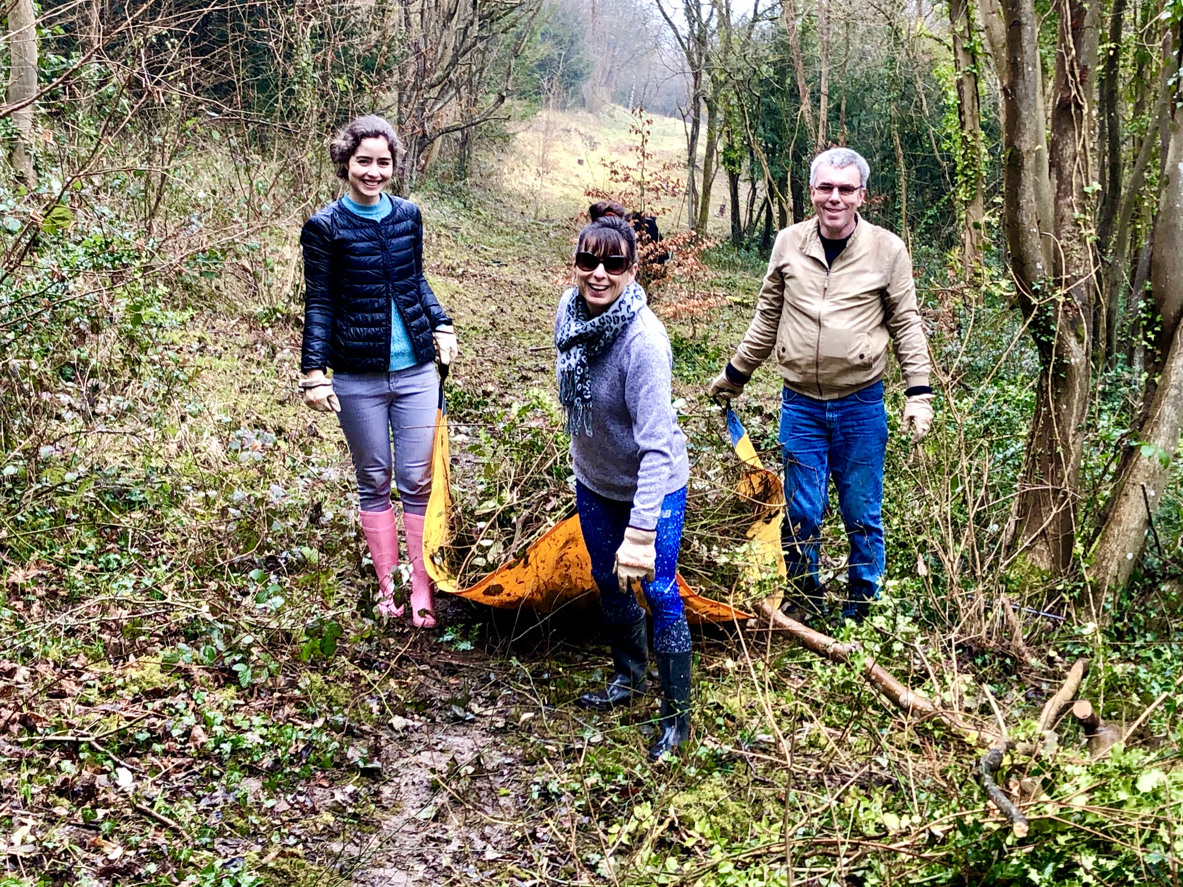 Volunteers dragging a tarpaulin